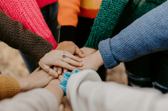 Manos unidas en señal de trabajo en equipo